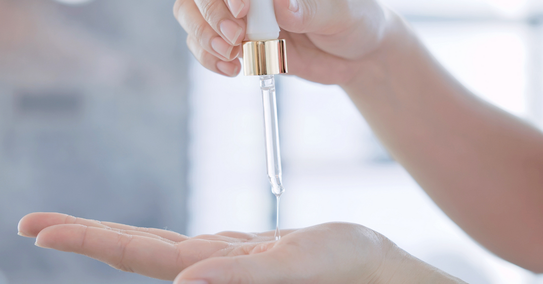 hand holding a dropper of lubricant
